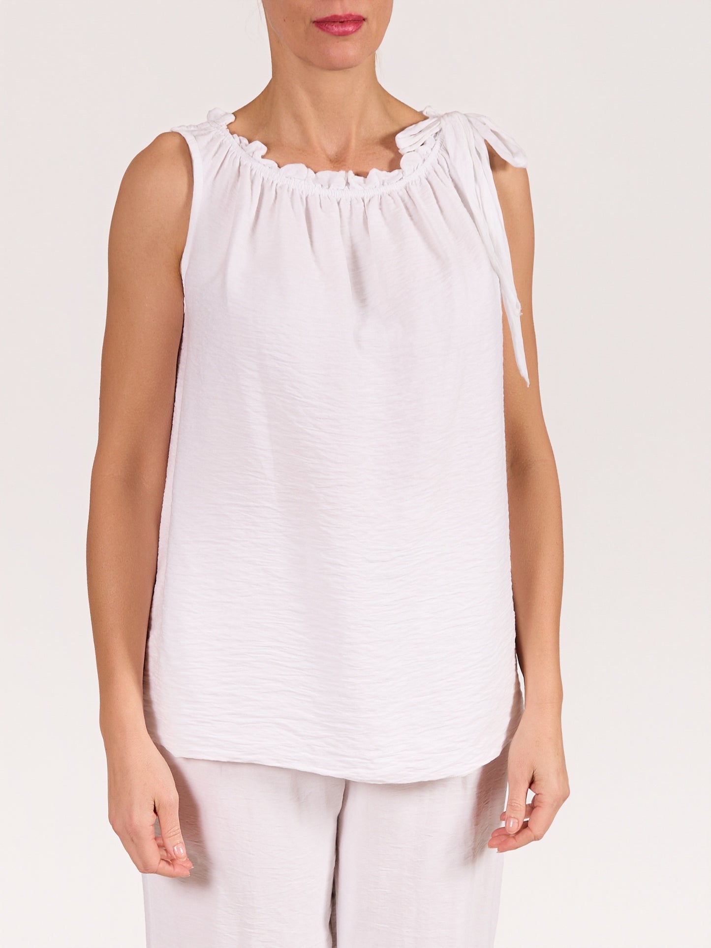 White Sleeveless Top with Ruffled Neckline and Side Tie